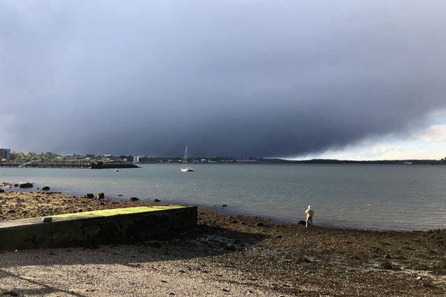 A dark storm cloud gathers over Long Island Sound as seen from the Bronx.